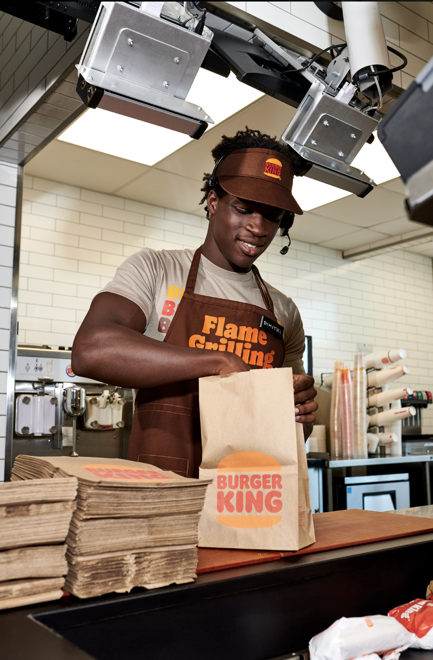 Burger King team member in a Flame Grilling apron packing a guest order in the kitchen
