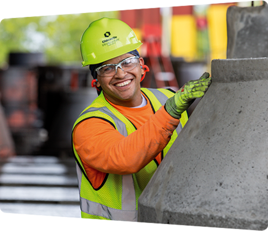A CRH team member smiling while working with a precast concrete product