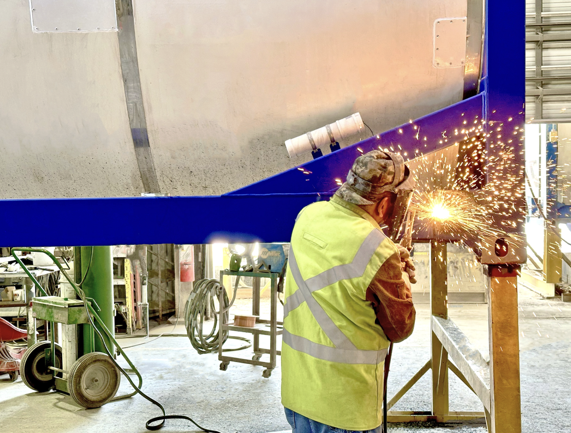 A DCI technician welding a tank frame, representing skilled hands-on careers open to everyone