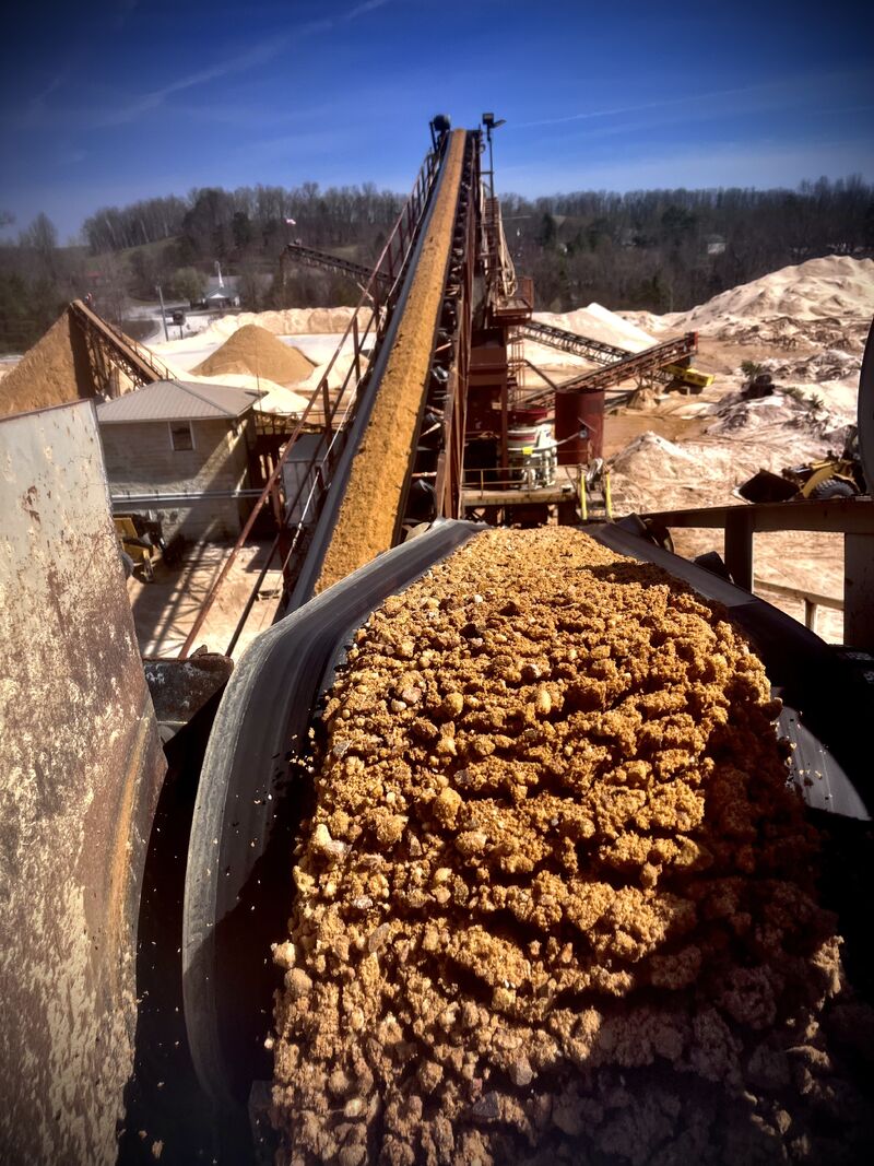 Freshly crushed aggregate pouring off a conveyor belt at a MidSouth Aggregates quarry