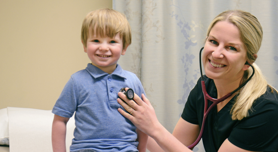 A Salina Regional Health Center nurse listening to a young patient's heartbeat with a stethoscope
