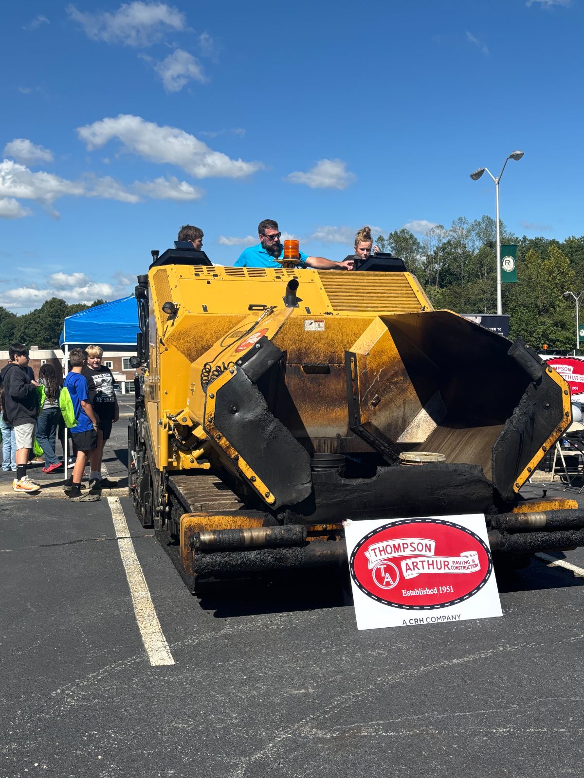 Thompson Arthur team showing students an asphalt paver at a community event