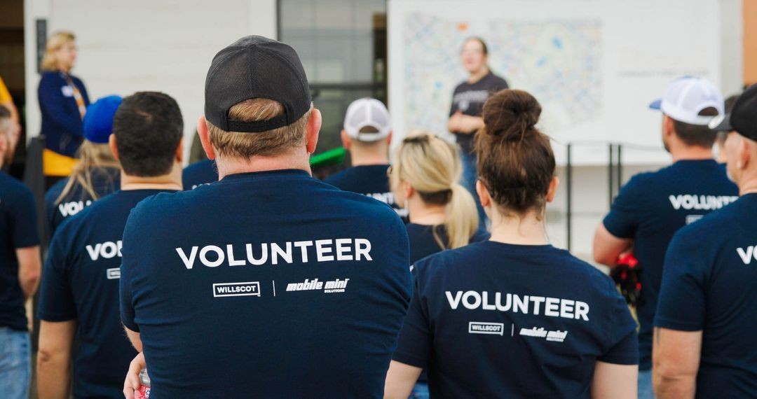 WillScot and Mobile Mini employees in branded VOLUNTEER shirts gathered together at a community event