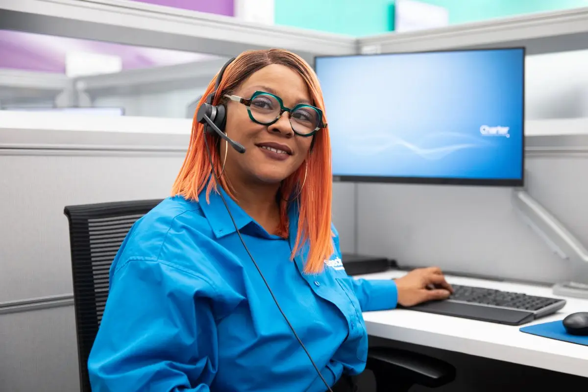 A Spectrum call center employee wearing a headset at her workstation